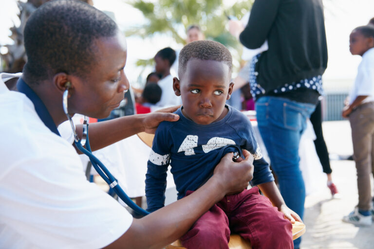 Shot of a volunteer doctor giving checkups to underprivileged kids
